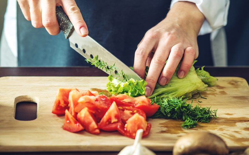 chef-chopping-vegetables Chef Chopping tomatoes, lettuce and herbs on a cutting board