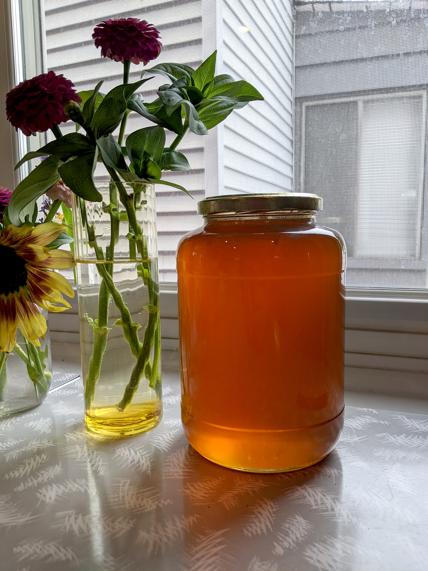 jar of local honey on counter with sunflower