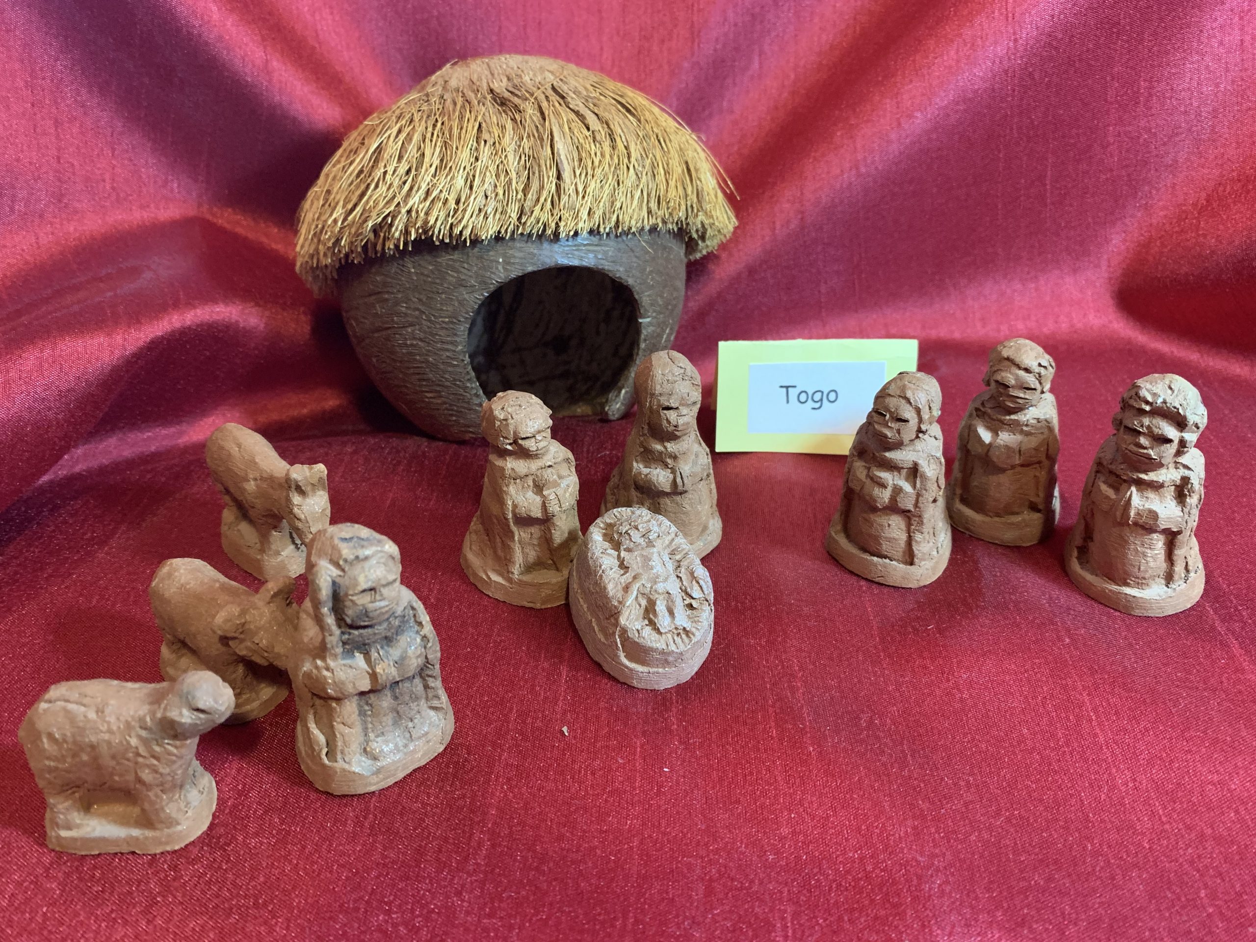 crèche from Togo is made from clay and the manger (building structure in background) is from a coconut.