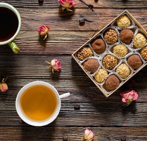 Katie Cyr - Tea & Chocolate 3 two cups of tea on a table next to a box of assorted truffles