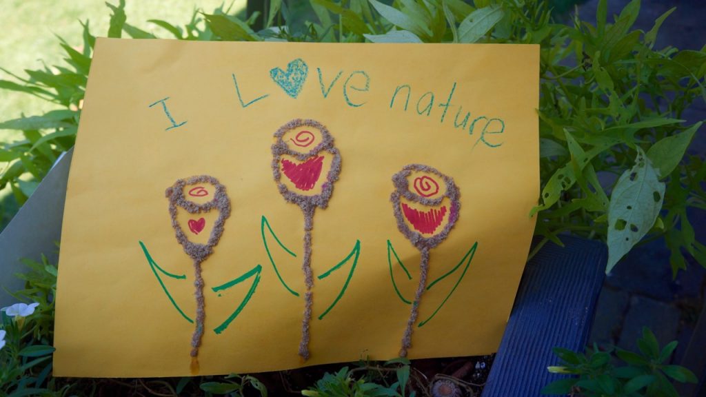 child's drawing of three flowers. I love nature is written in blue crayon above the flowers.