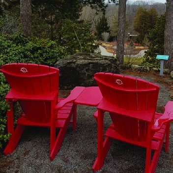 Red Muskoka Chairs overlooking the rock garden