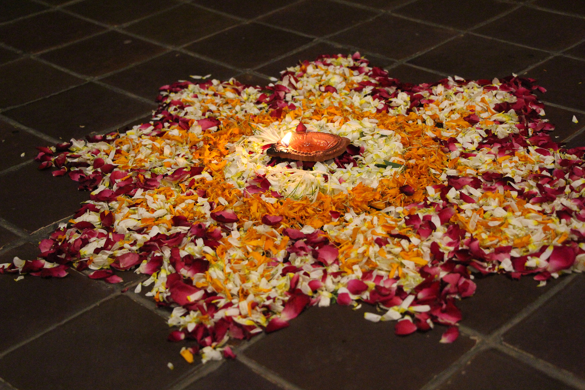 Rangoli display with petals and candles