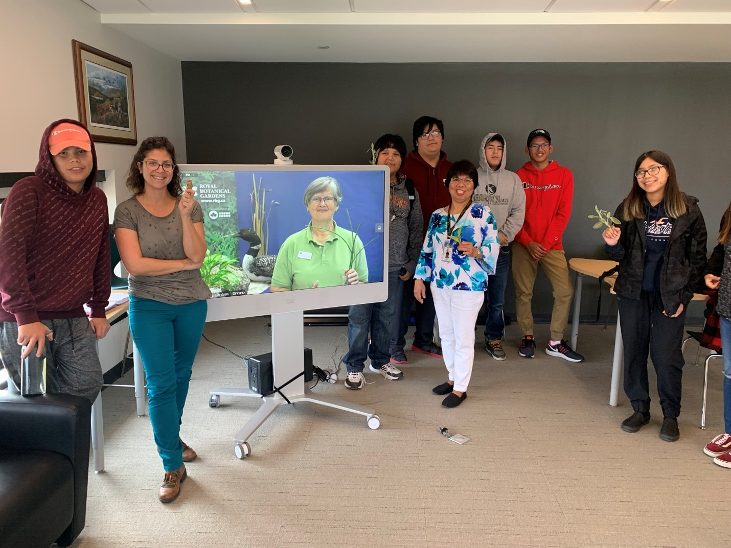 Students standing around a large smart board screen. Karin is presenting on the RBG